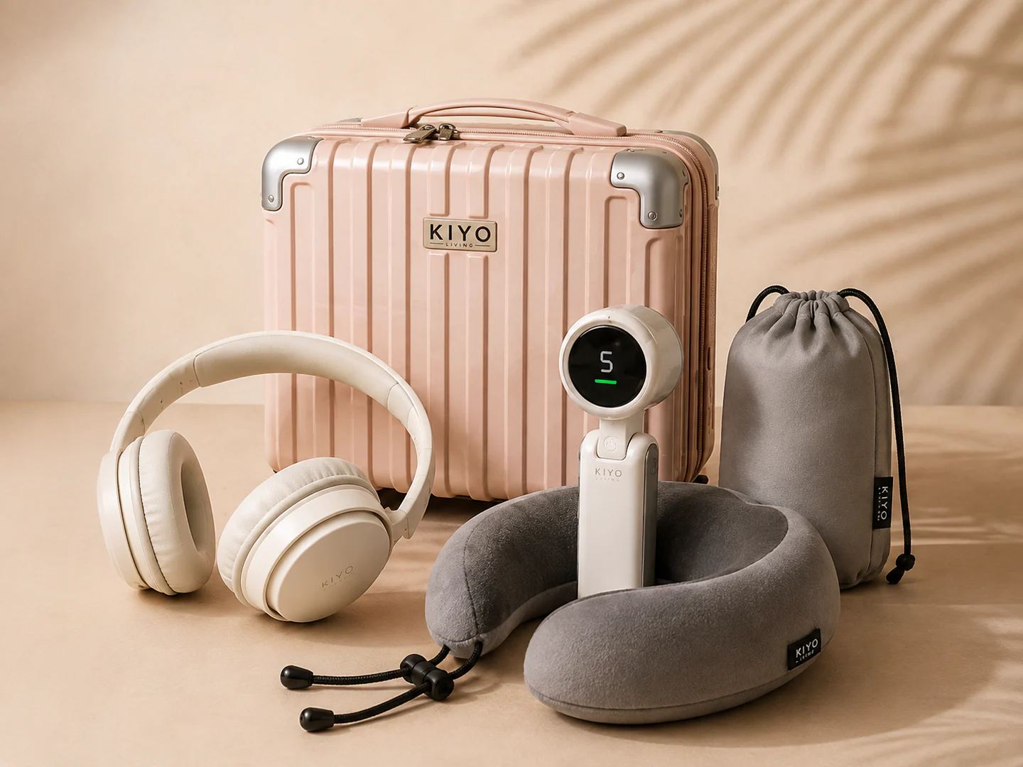 Pink mini luggage with headphones, neck pillow, portable fan and drawstring pouch